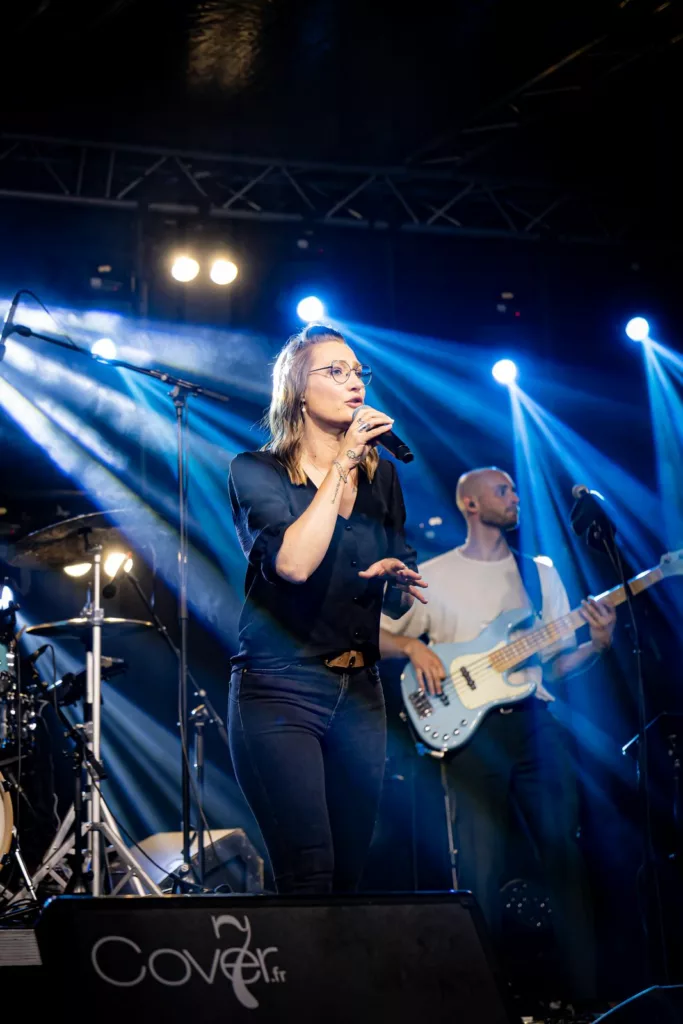 Chanteuse et bassiste de Cover7 sous les lumières, 14 juillet à Marles-les-Mines