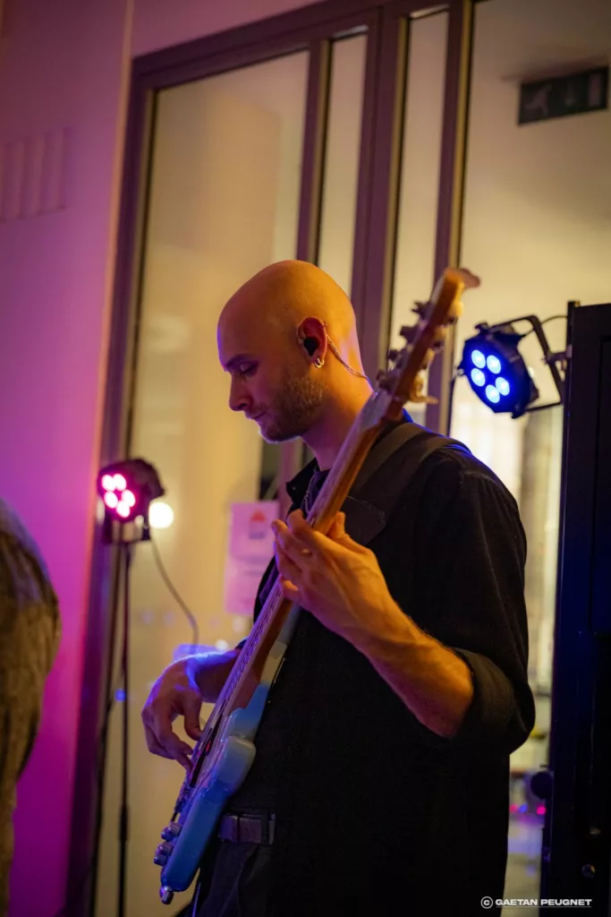 Bassiste de Cover7 sous les lumières, concert au musée La Piscine