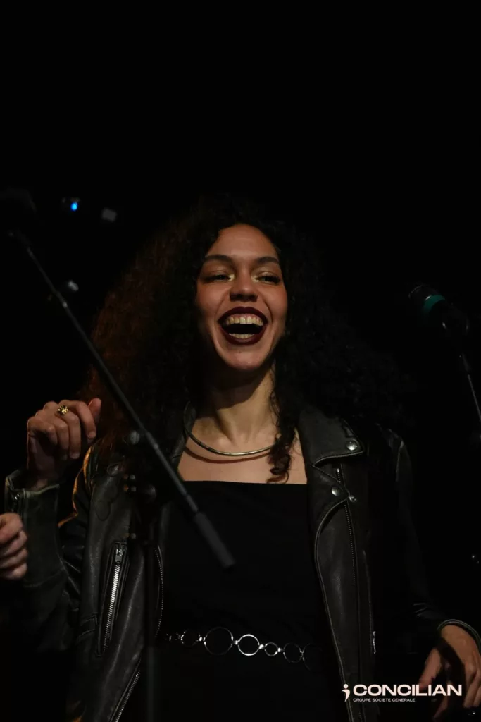 Chanteuse de Cover7 souriante sur scène pendant la soirée Concilian au Zéphyr